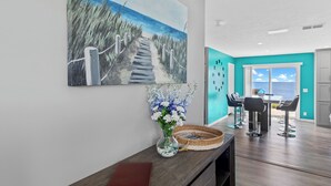 A modern interior with a beach-themed painting, a vase with flowers, and a dining area with bar stools. - Lighthouse Retreat Close to Lambeau Field
and the amazingDoor county Fall Color (Algoma)