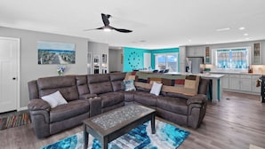 A modern living room with a sectional sofa, a coffee table, and a ceiling fan. - Lighthouse Retreat Close to Lambeau Field
and the amazingDoor county Fall Color (Algoma)