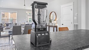 A Ninja Smoothie Blender on a kitchen counter with a modern kitchen layout, including a dining area with chairs and a table. - Spacious Duplex, Near VCU, 5 Free Parking, Fenced (Richmond)