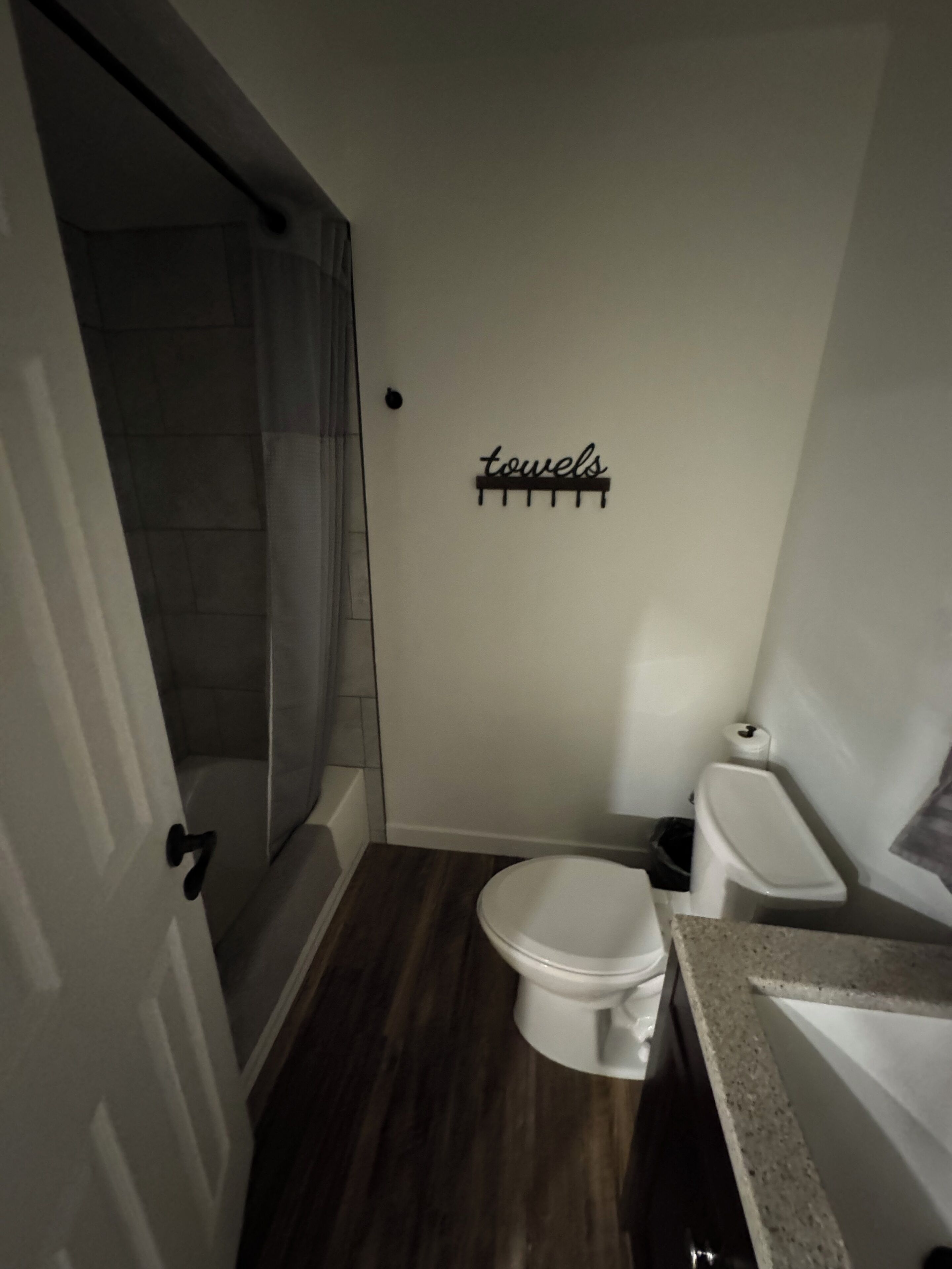 A small bathroom with a shower, toilet, and sink.