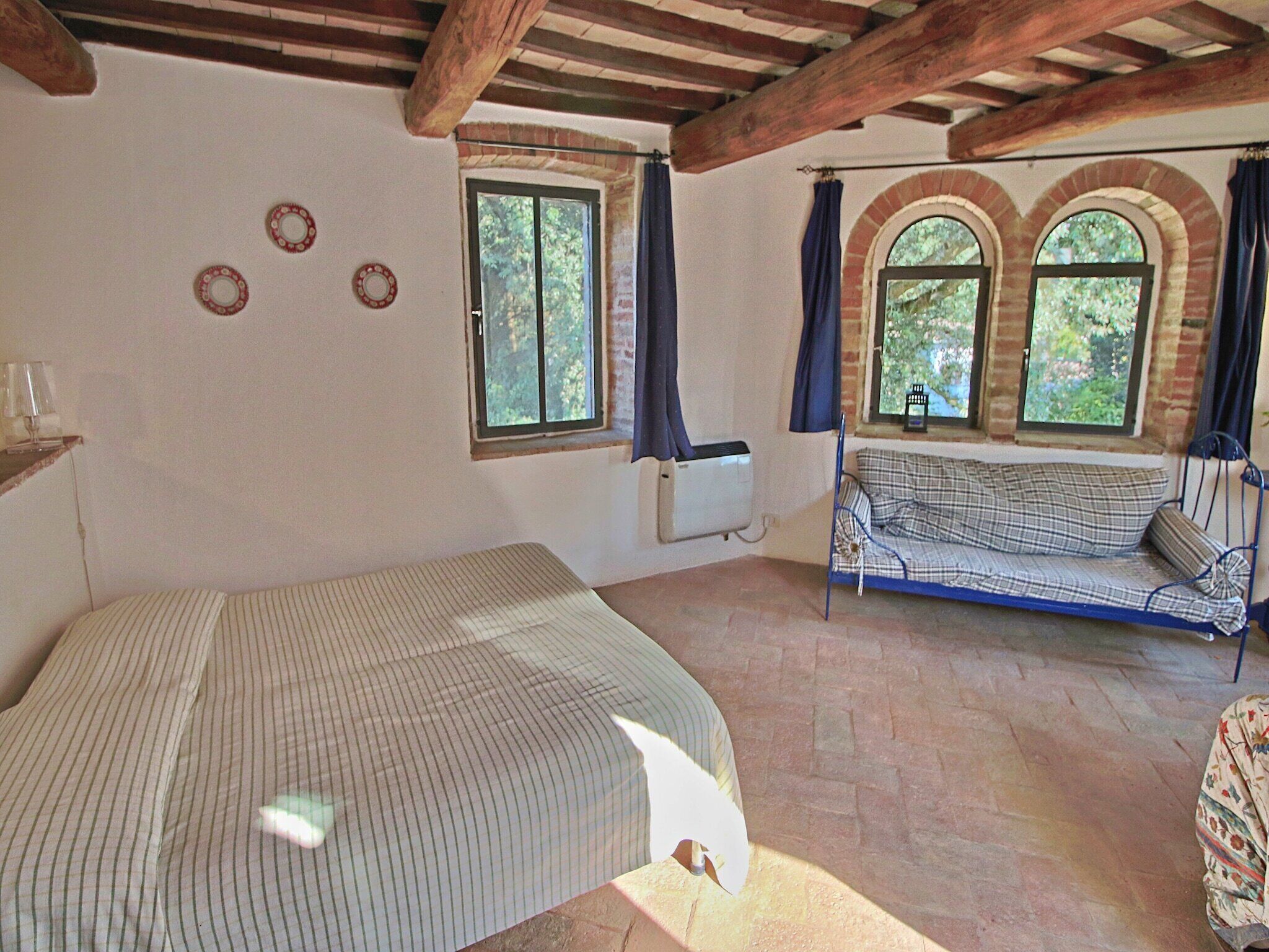 Ein Zimmer mit einem Bett, einem Sofa und einem fenster mit Vorhängen.