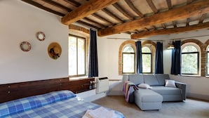 Une pièce avec un lit, un canapé et une fenêtre avec des rideaux.