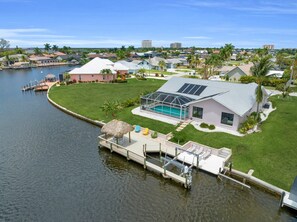 A waterfront property with a swimming pool, dock, and a large glass greenhouse. - New listing - Villa Pelican Rose - Gulf access w. heated pool (Cape Coral)