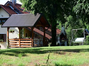 A wooden gazebo with a tiled roof, a brick chimney, and a bench. - Apartment near Plitvička Lake and Korana River (Selište Drežnićko)