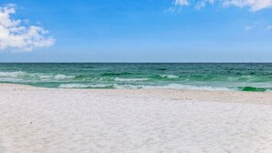 A beach with white sand and a clear blue sky. - Sundunes 133 in Navarre Beach | Beachfront | Pool | My Beach Getaways (Navarre)
