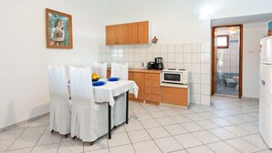 A small kitchen with a dining table, chairs, a coffee maker, and a toaster. - Holiday Home in Jasenice near Maslenica Beach (JASENICE)