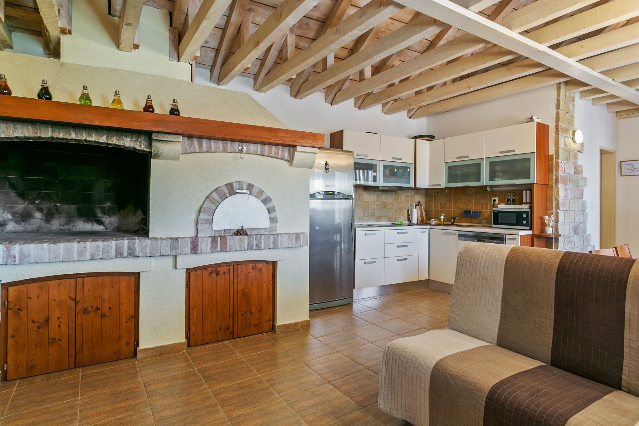 Une cuisine spacieuse dotée d’un four encastré, de meubles en bois et d’un réfrigérateur moderne.