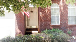 A brick building with a white door and two arched windows.