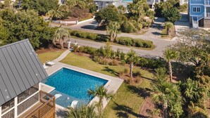 A residential area with a swimming pool, houses, and a view of the ocean. - Spacious Second-Row Home Across from Beach Access (Georgetown)