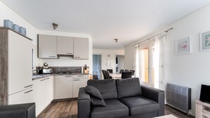 A modern apartment with a kitchen, living area, and dining space. - Luxury Holiday Home in Bantega with Harbour and Sloop (Bantega)