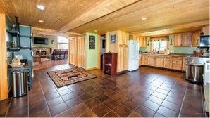 Eine geräumige Küche mit Holzausstattung, einem Kühlschrank und einem Essbereich mit Sofa und Tisch.