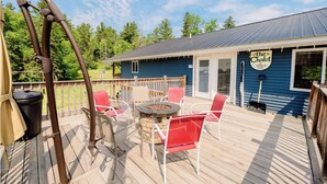 Eine Terrasse mit Sitzgelegenheit im Freien, einer Feuerstelle und einem Schild mit der Aufschrift 'The Chalet at Kern's Inn'.