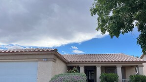 Ein Wohnhaus mit Garage, gepflegtem Rasen und blauem Himmel.