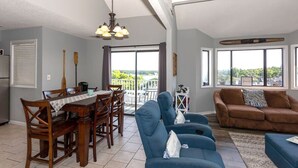 A spacious living area with a dining table, blue sofas, and a brown couch.