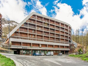 Et hotel med flere etager og et unikt arkitektonisk design, med altaner og et skiliftskilte.