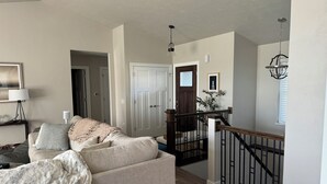 A living room with a sofa, a lamp, and a framed picture on the wall. - Full home available for EAA 2025. Minimum 7 day rental. (Oshkosh)