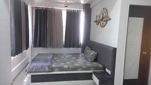Un dormitorio con cama, cortinas, ventilador de techo y un adorno en la pared.