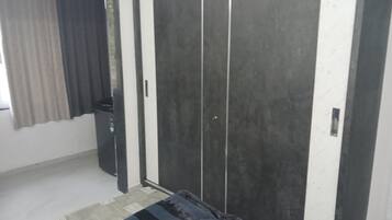 A room with a sliding door, a patterned rug, and a window with curtains.