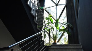 Una scala con ringhiera in metallo e una pianta in vaso all'estremità superiore.