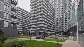 A modern apartment building with multiple balconies and a pedestrian walkway.