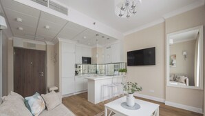 A modern living room with a sofa, a coffee table, and a kitchen in the background.