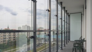 A balcony with a view of a cityscape, including buildings and a road.
