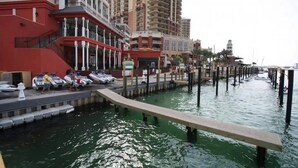 Une zone riveraine avec un quai, des bateaux et des bâtiments.
