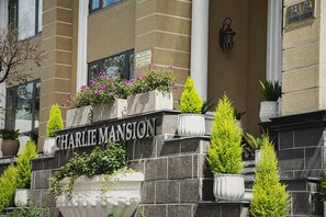 Fachada de un edificio con el nombre "CHARLIE MANSION" bien visible.