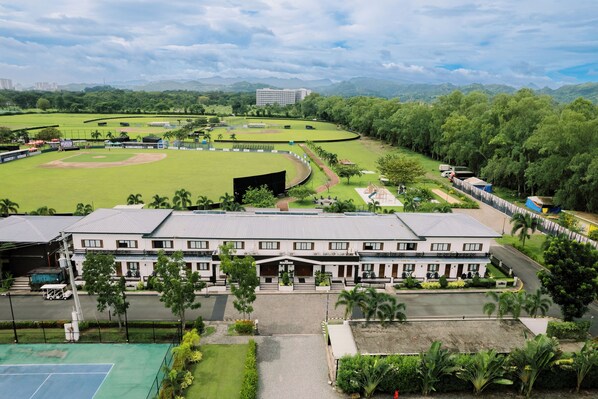 Ein großes Hotel mit Innenhof, umgeben von üppigem Grün und einem Baseballfeld.