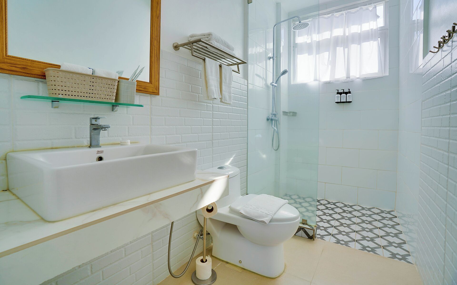 Un baño moderno con lavamanos, inodoro y ducha blancos.