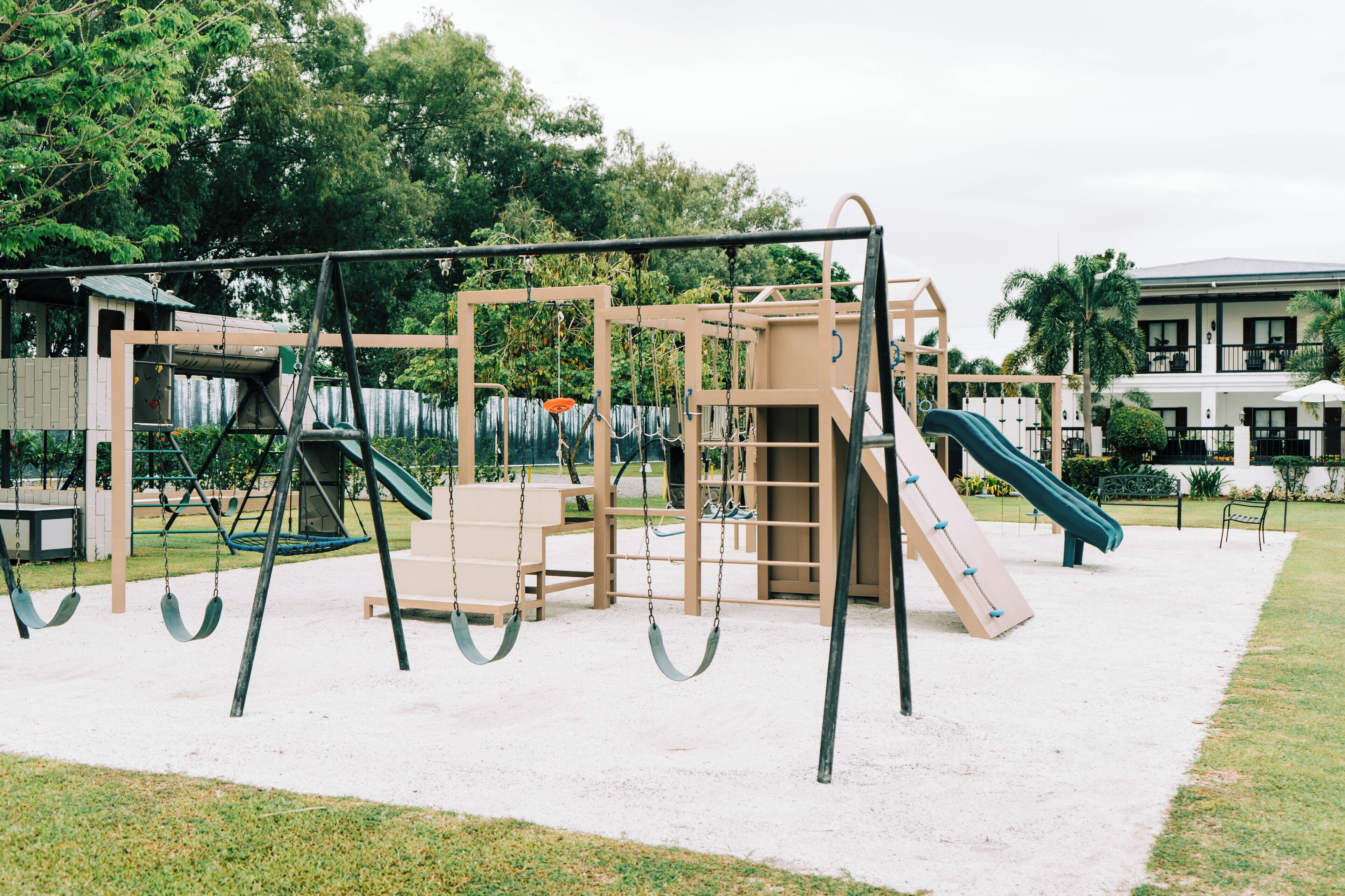 Un parque infantil con columpios, toboganes y estructuras para escalar.