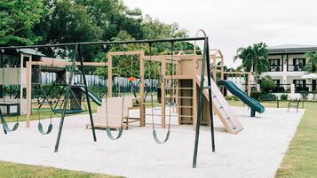 Un parque infantil con columpios, toboganes y estructuras para escalar.