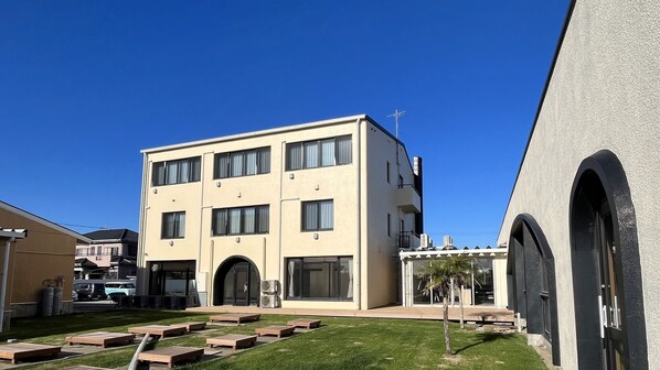 A multi-story building with a flat roof, large windows, and a central entrance. - Luana Hasunuma HOTEL&CAFE (Sanmu)
