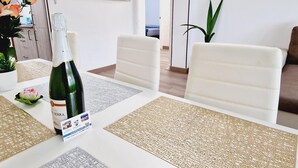 A dining area with a table set for two, featuring woven placemats and a bottle of wine. - Los Cristianos, 3 Bedrooms & WiFi Free (LOS CRISTIANOS)