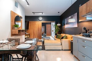 Una cocina moderna con comedor, un sofá y un reloj en la pared.