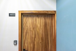 Een houten deur met een nummerplaat waarop kamer 402 staat.