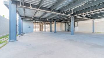 An indoor parking garage with concrete floors, metal beams, and a staircase.