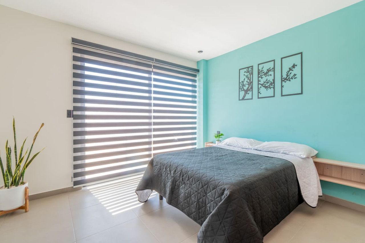 Una camera da letto con un letto, una pianta in vaso e una porta scorrevole.