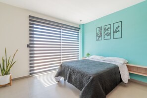 Une chambre à coucher avec un lit, une plante en pot et une porte coulissante.
