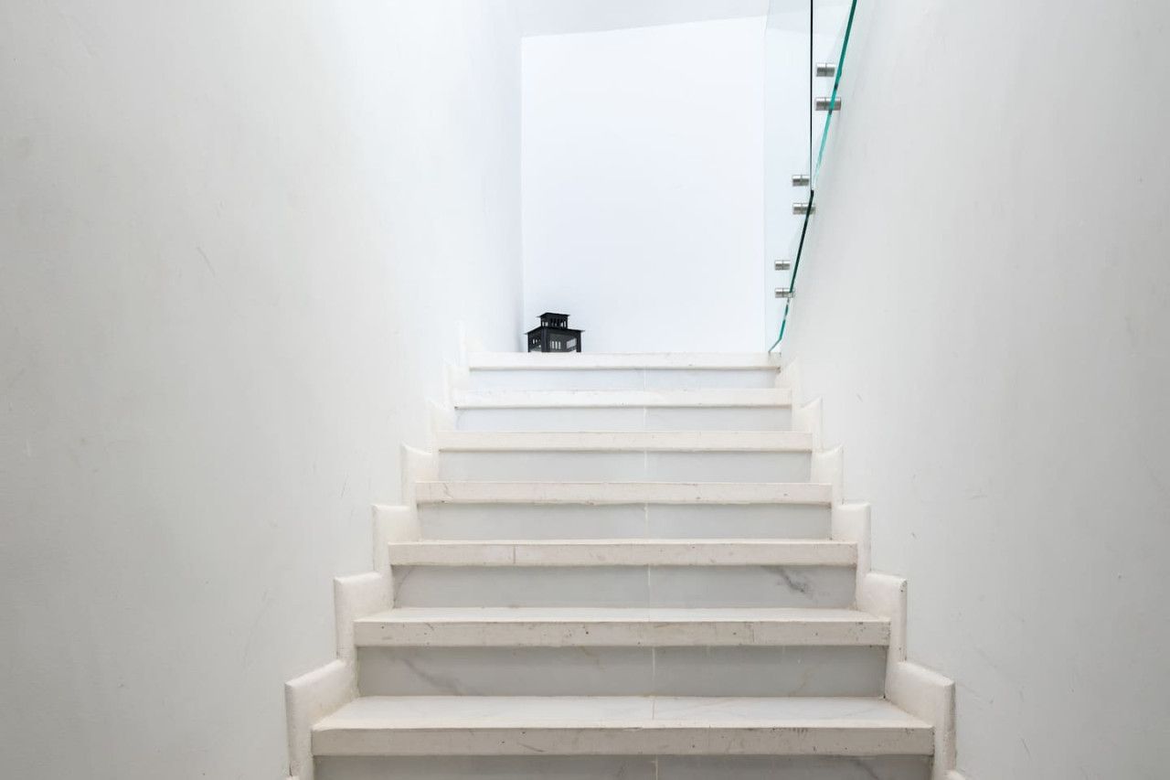 A staircase with white steps leading to a landing.