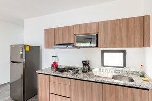 A modern kitchen with a built-in oven, a refrigerator, a microwave, a coffee maker, and a sink. - Hermoso Depa Ejecutivo en el Corazon de Mazatlán (Mazatlán)