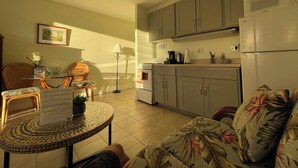 A compact kitchen with a refrigerator, stove, and microwave. There is a dining area with a table and chairs, and a small round table with a menu. - 🤩Great location🤩 8 guests~same floor (6)~ ✅ 2 studios ✅ free parking (Honolulu)