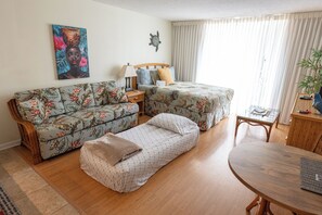 A room with a sofa, a bed, a table, and a painting on the wall. - 🤩Great location🤩 8 guests~same floor (6)~ ✅ 2 studios ✅ free parking (Honolulu)
