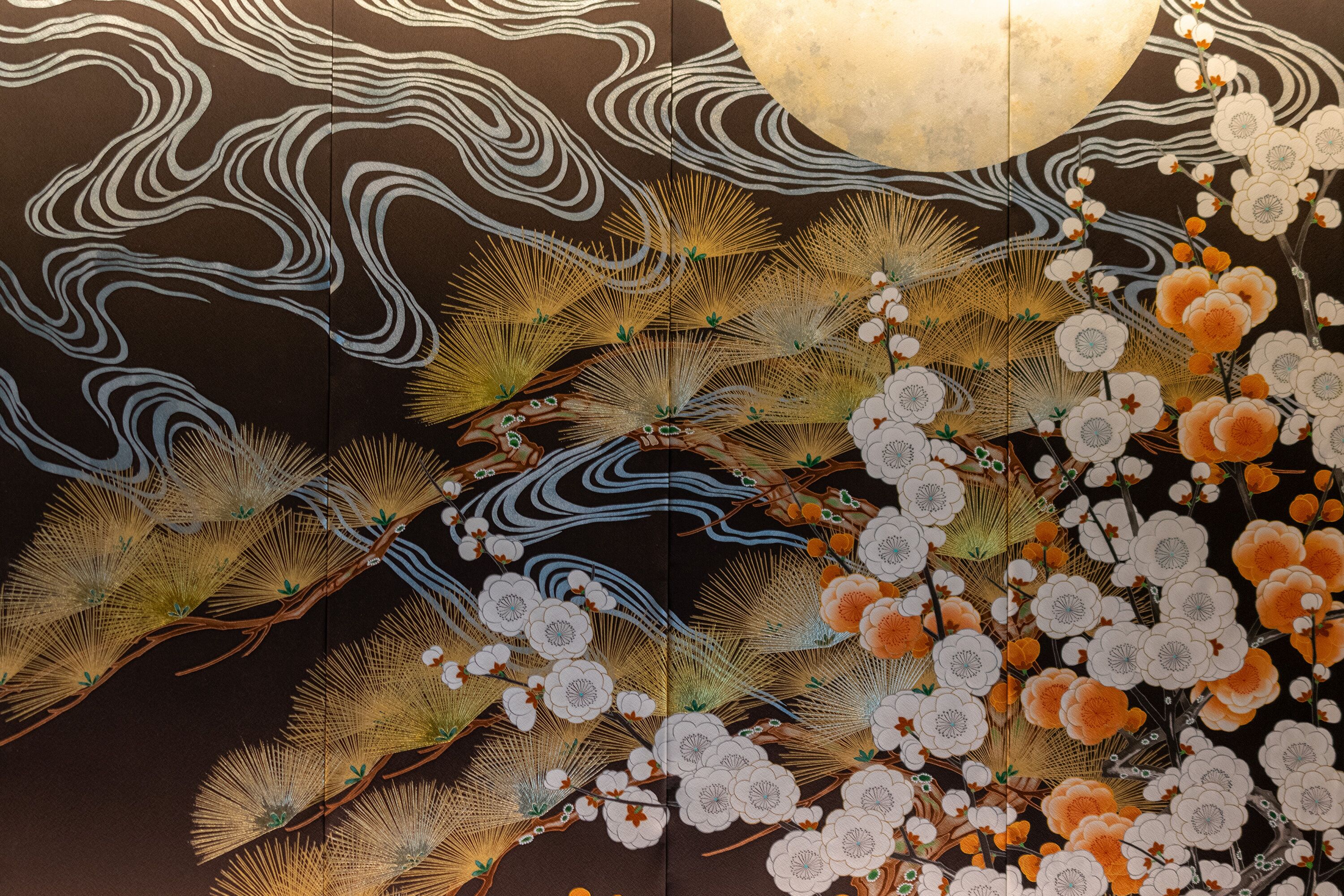 Un interior japonés tradicional con intrincados diseños de olas y motivos florales en las paredes.