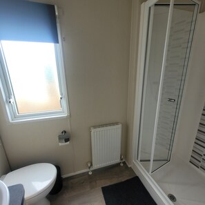 A bathroom with a toilet, a window, a radiator, and a shower. - Beachside Lodge - Sleeps 6 - Pets ok - Plus Parking (Morecambe)