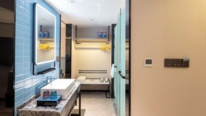 Een moderne badkamer met een marmeren aanrechtblad, een grote spiegel, een handdoekhouder en een ingebouwde verwarming.