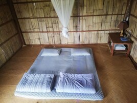 Una habitación con una cama, una mesita de noche y un dosel.