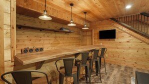 A wooden interior with a bar area, chairs, and a staircase. - Modern Rustic Retreat ~Newly Built with Hot Tub and EV charger, ~6mi to Ash Cave (Creola)