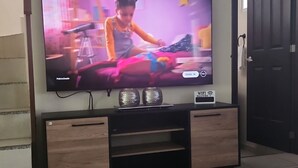 Et fjernsyn ophængt på en væg med et tv-møbel under.