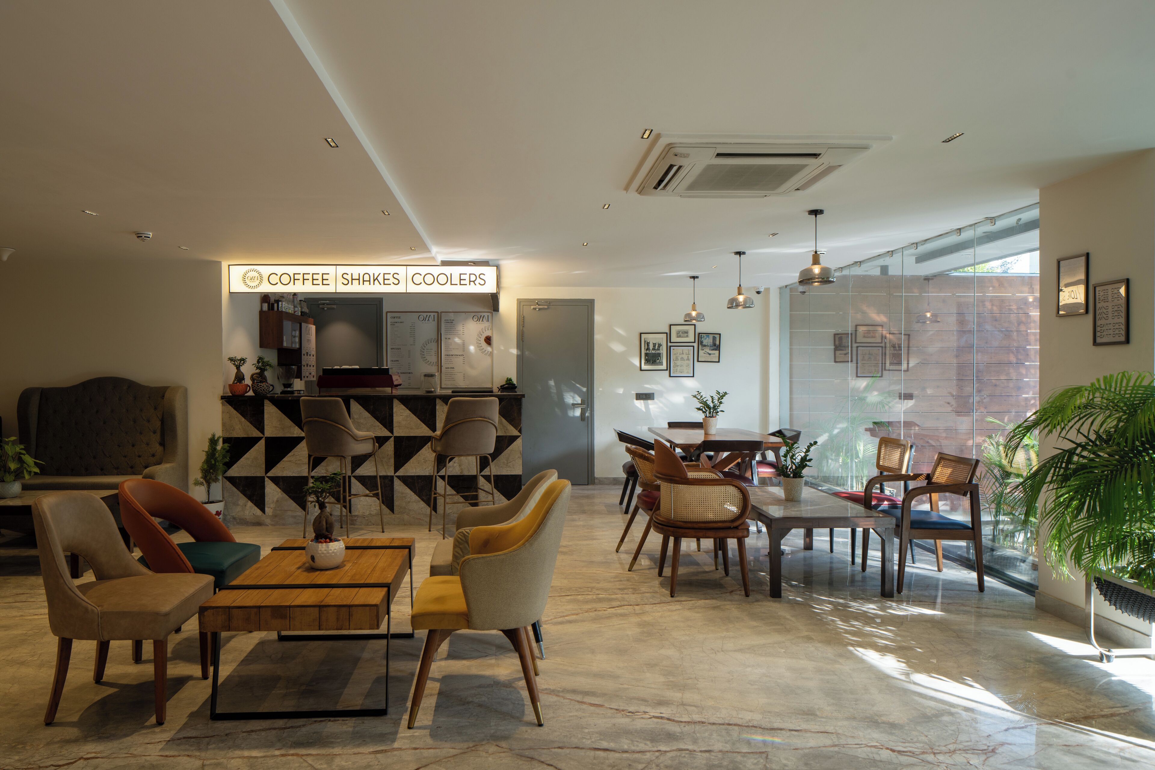 A modern interior with a coffee bar, seating area, and large windows.